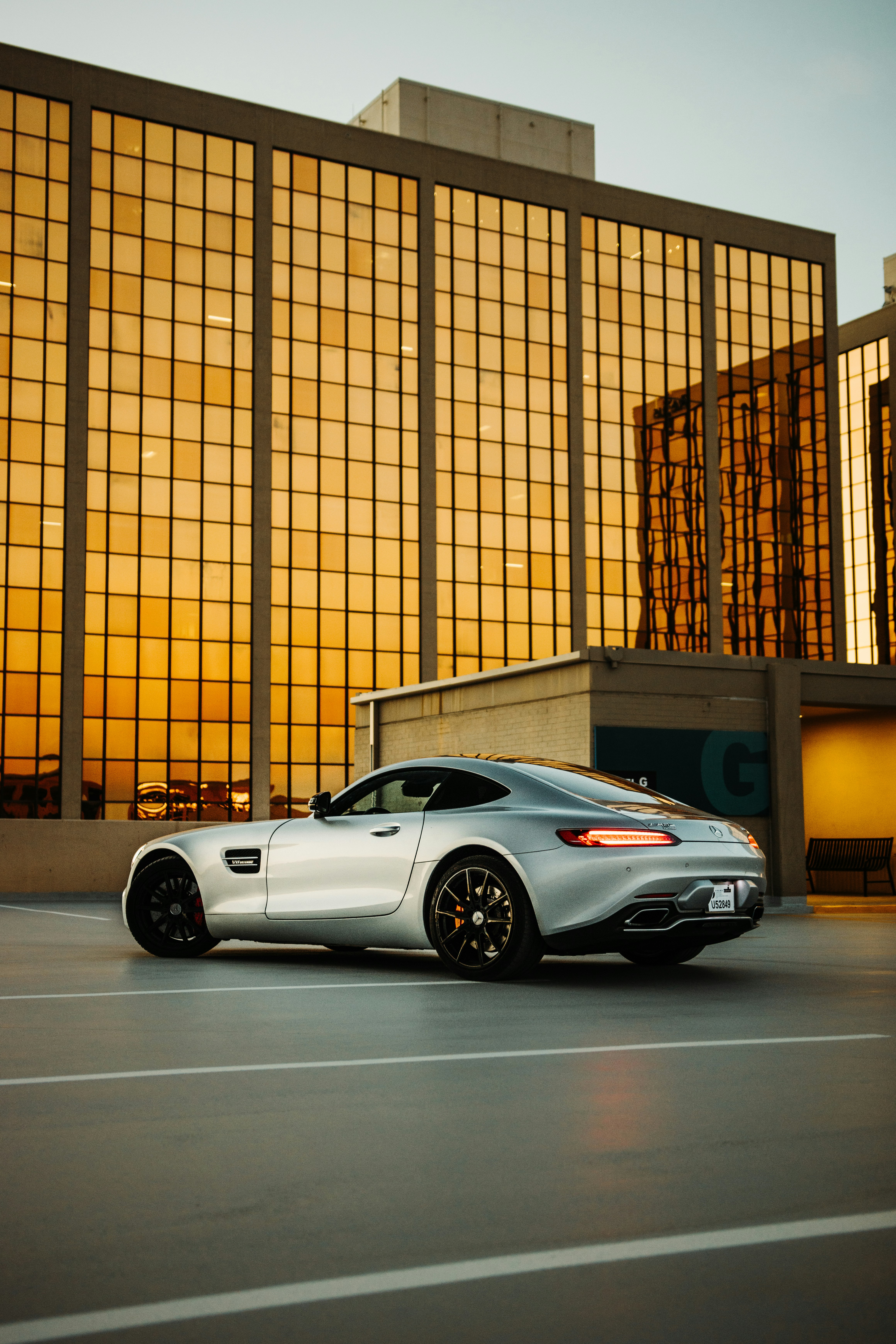 white porsche 911 parked in front of brown building